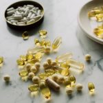 Close-up of various pills and capsules scattered on a marble surface, symbolizing healthcare and medicine.