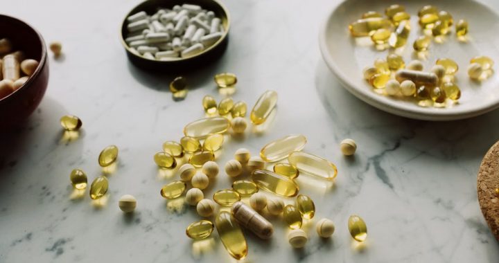 Close-up of various pills and capsules scattered on a marble surface, symbolizing healthcare and medicine.
