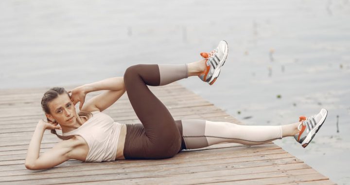 A woman exercises by a lake, demonstrating a healthy lifestyle and fitness routine.